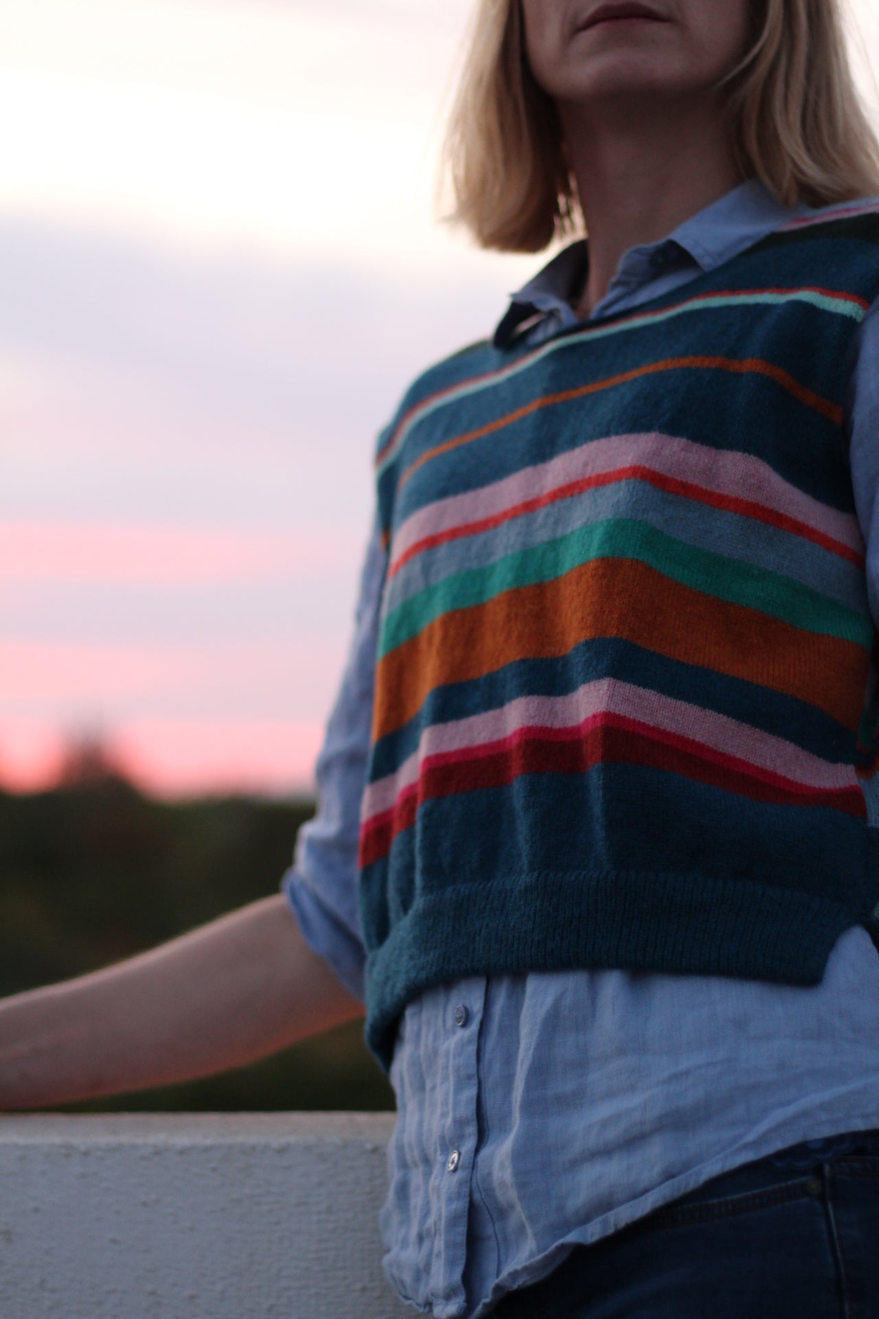 Person wearing a colorful striped shirt with a blurred background