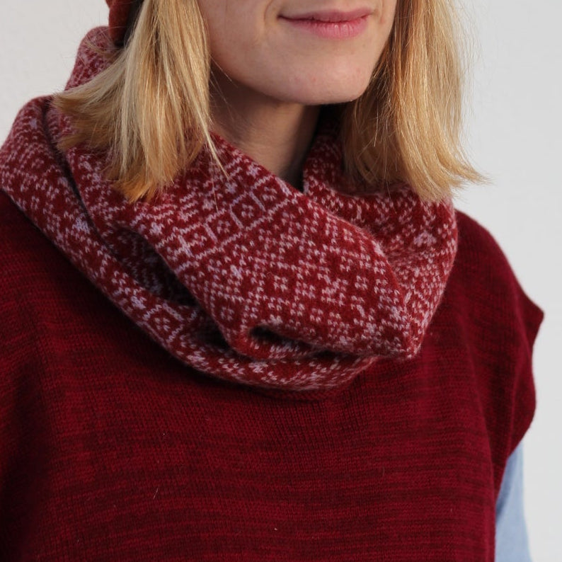 Person wearing a red beanie and scarf on a snowy background