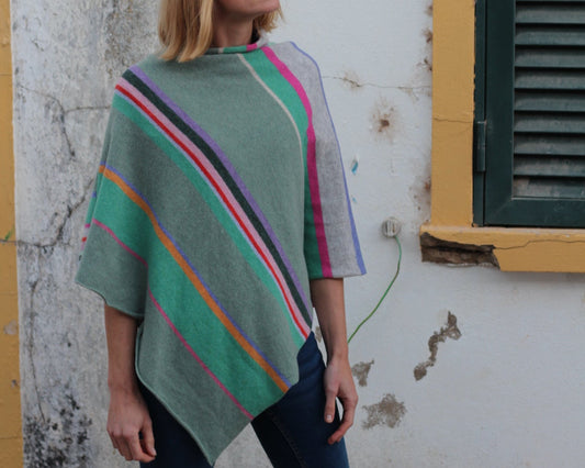 Person wearing a colorful striped poncho in an urban setting