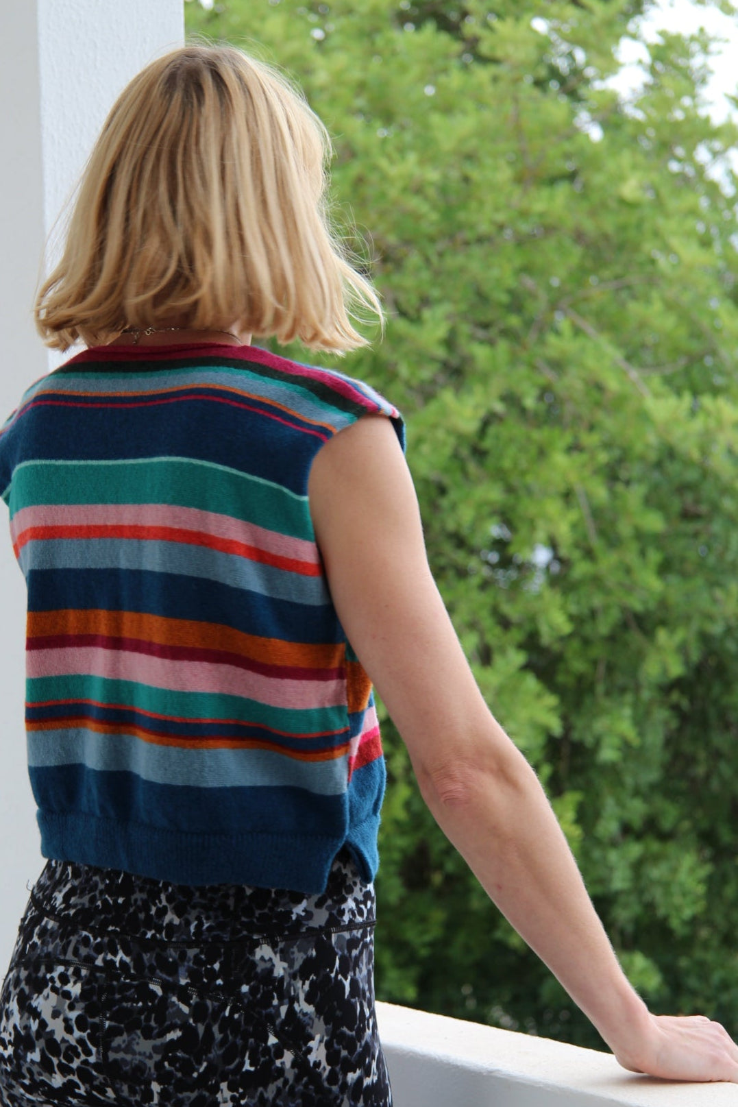 Person wearing a colorful striped shirt with a blurred background